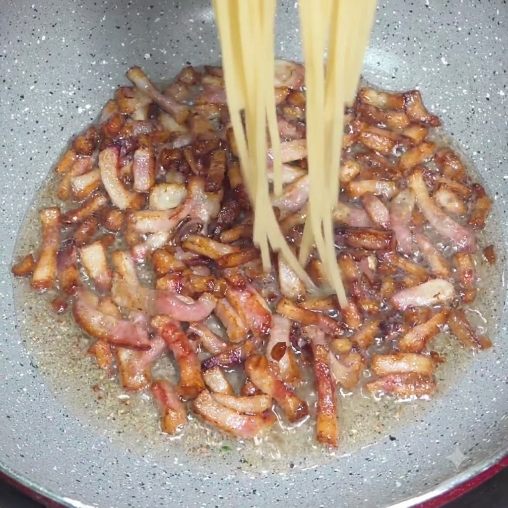 Spaghetti cotti trasferiti con una pinza in una padella con pezzi di guanciale croccante.