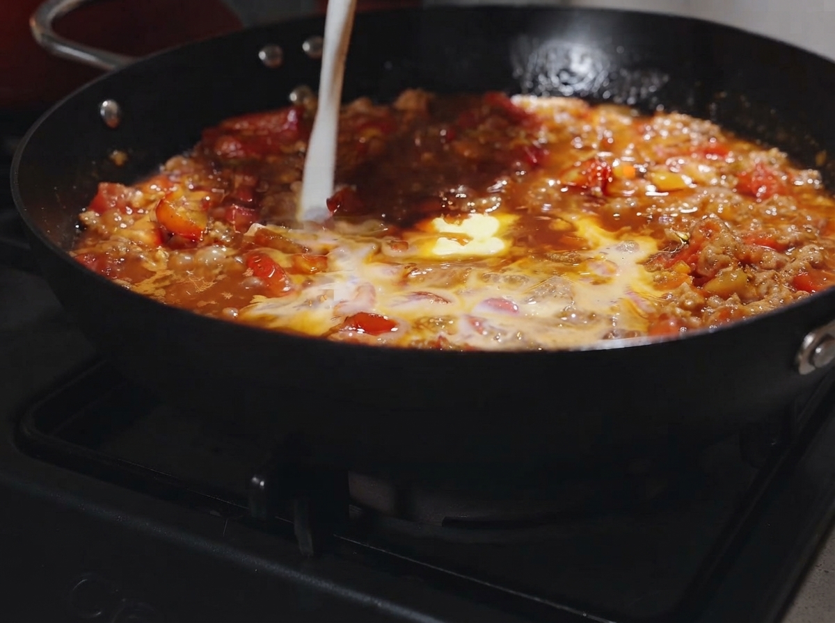 Un pezzetto di burro e un goccio di latte versati nel ragù gorgogliante.