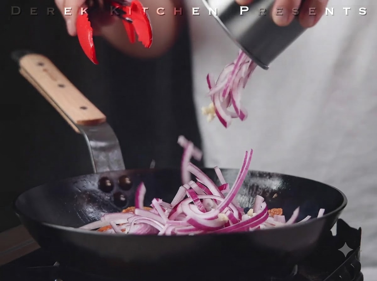 Cipolle rosse a fette e aglio versati nella padella sopra il salame.