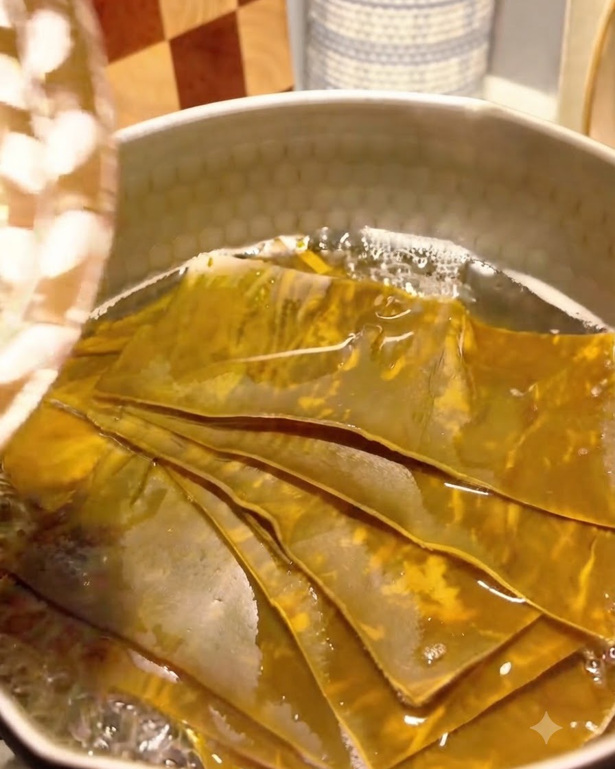 Fiocchi di bonito aggiunti al brodo di kelp in ebollizione in una pentola.