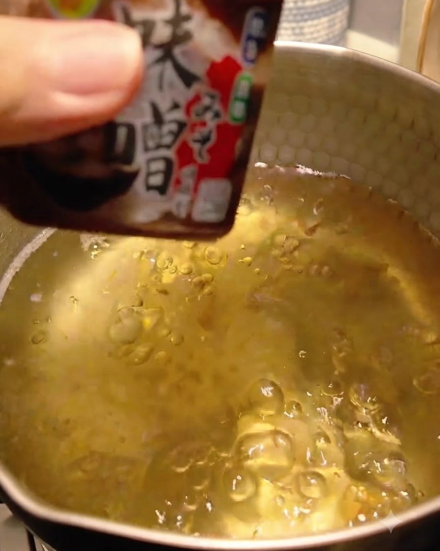 Pasta miso aggiunta e sciolta nel brodo dashi.
