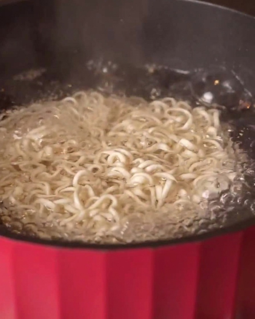 Spaghetti ai cereali che bollono in una pentola di acqua calda.