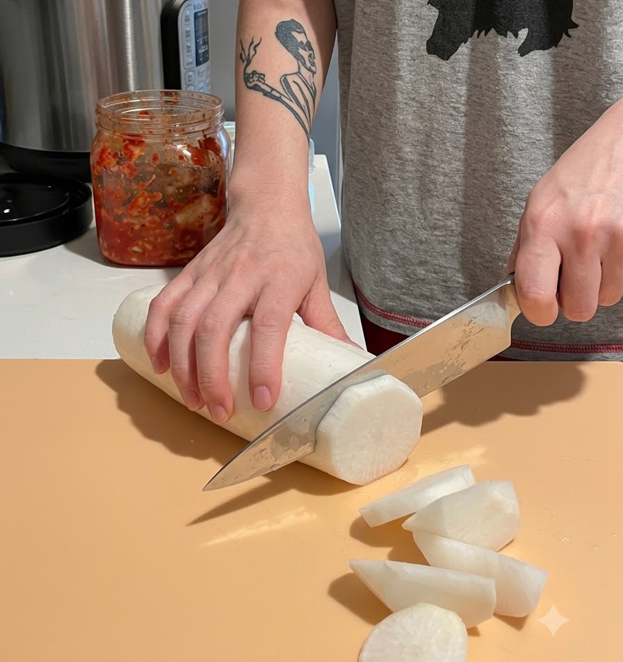 Affettare un ravanello daikon bianco pelato in pezzi grandi e spessi su un tagliere.