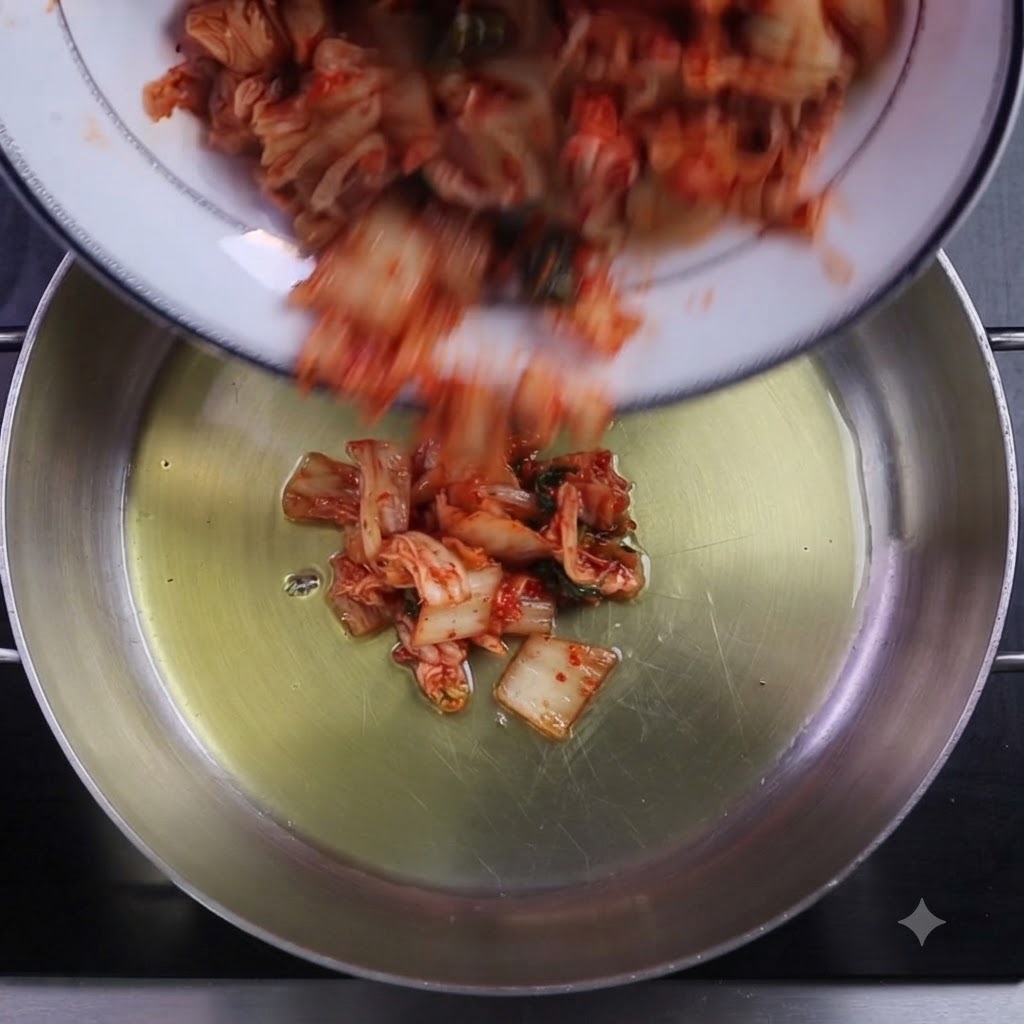 Kimchi tritato e peperoncino in polvere versati in una pentola da cucina oliata.