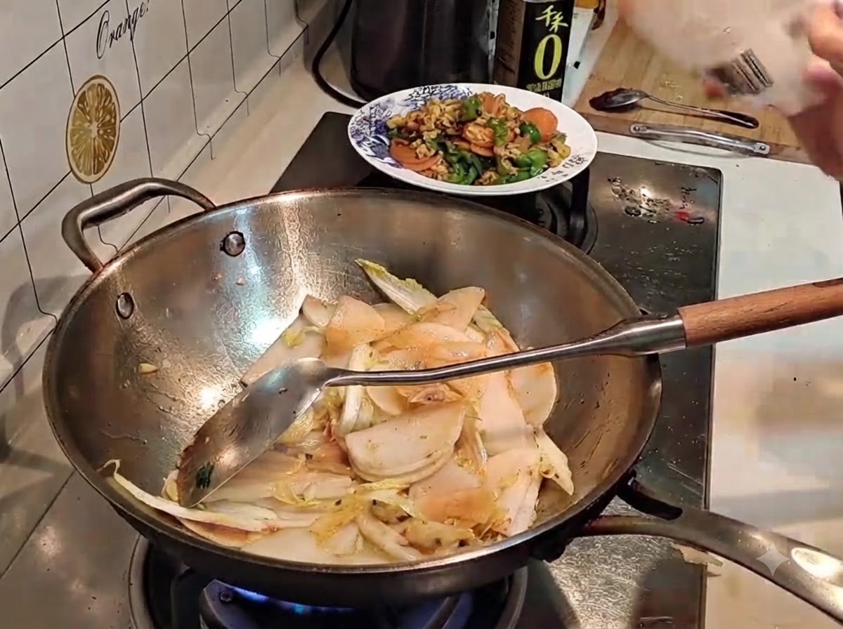 Sale spolverato da una bustina in un wok contenente verdure affettate e saltate.