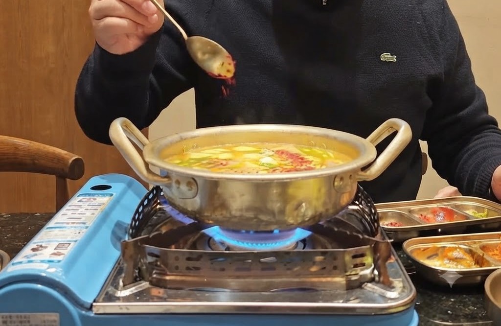 Un cucchiaio di peperoncino rosso in polvere spruzzato sopra una pentola ribollente piena di verdure e brodo.