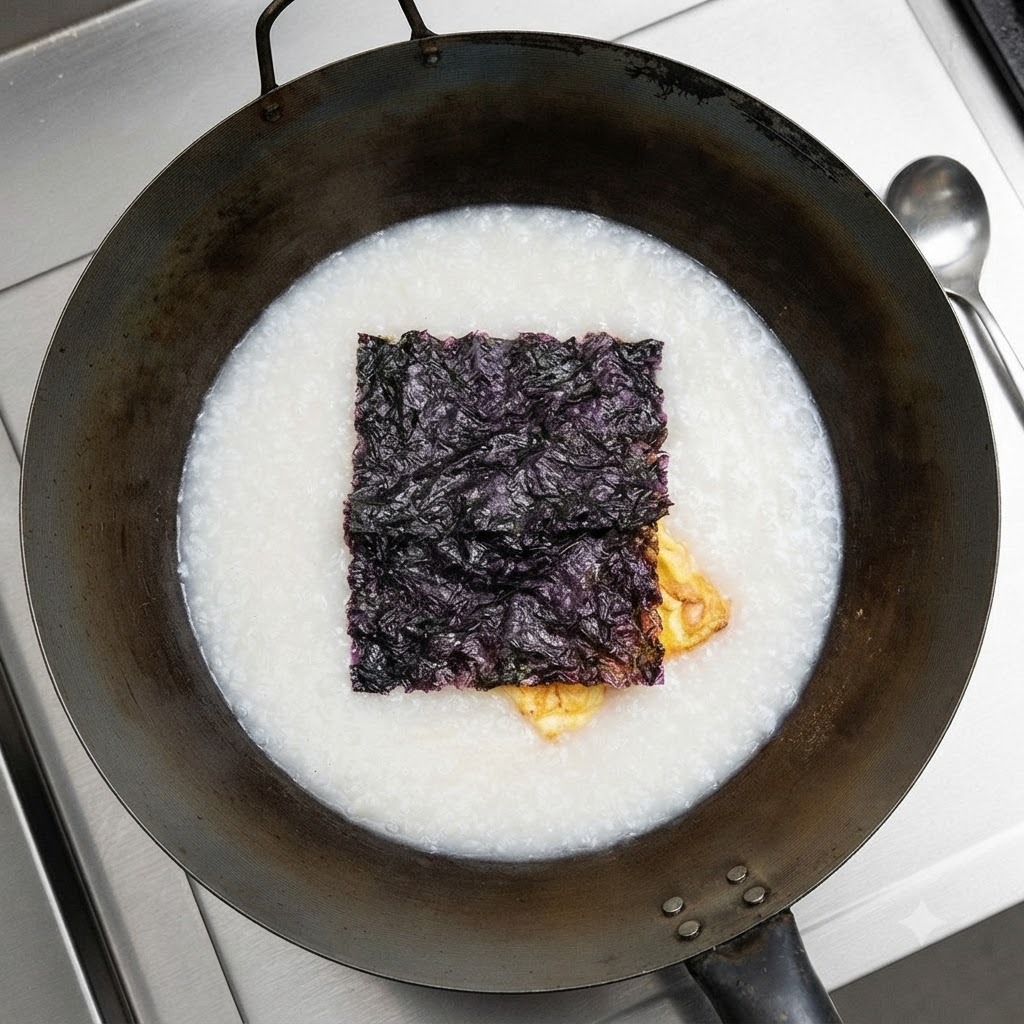 Alghe essiccate che galleggiano sopra la zuppa bianca nel wok.