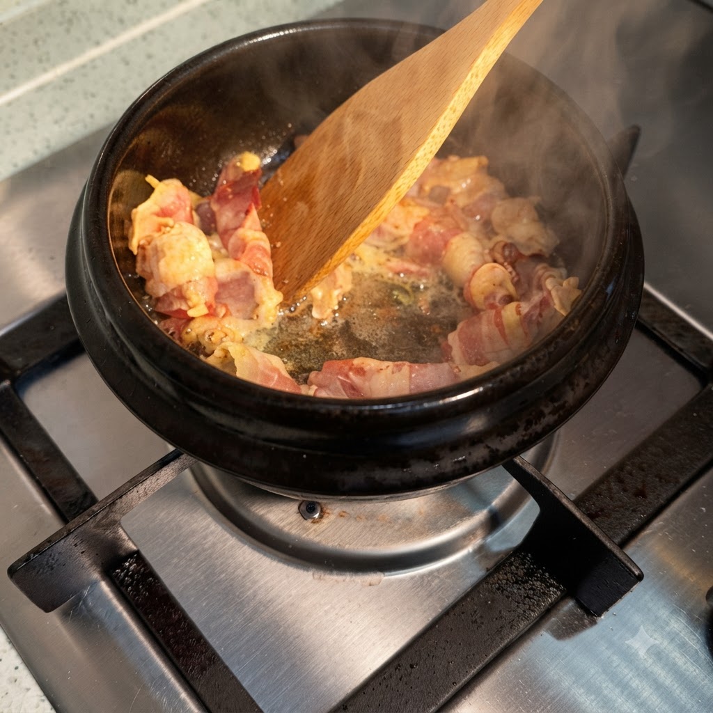 Salsa di soia versata sopra le fettine di manzo sfrigolanti dentro una pentola calda, creando vapore.
