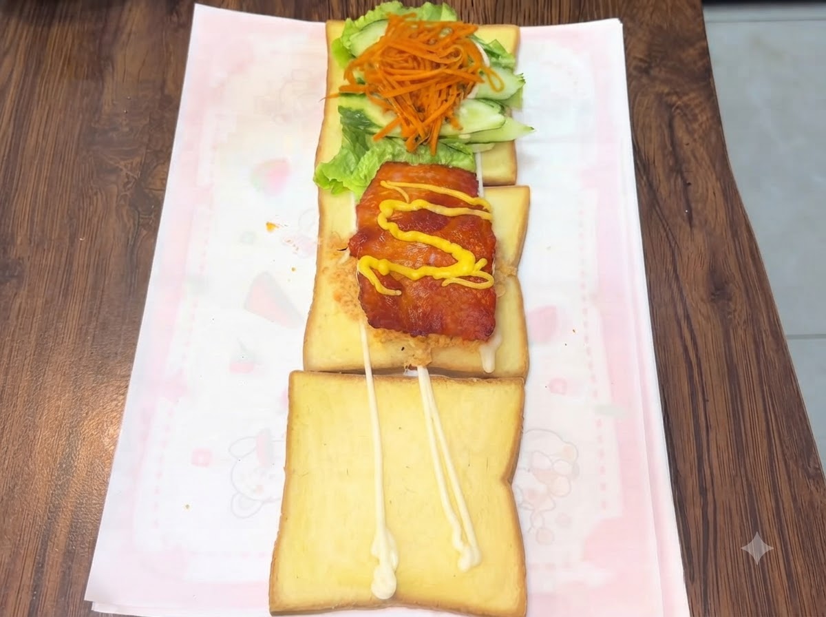 Spremitura di senape al miele gialla e ketchup rosso in linee a zigzag sopra una cotoletta di pollo.