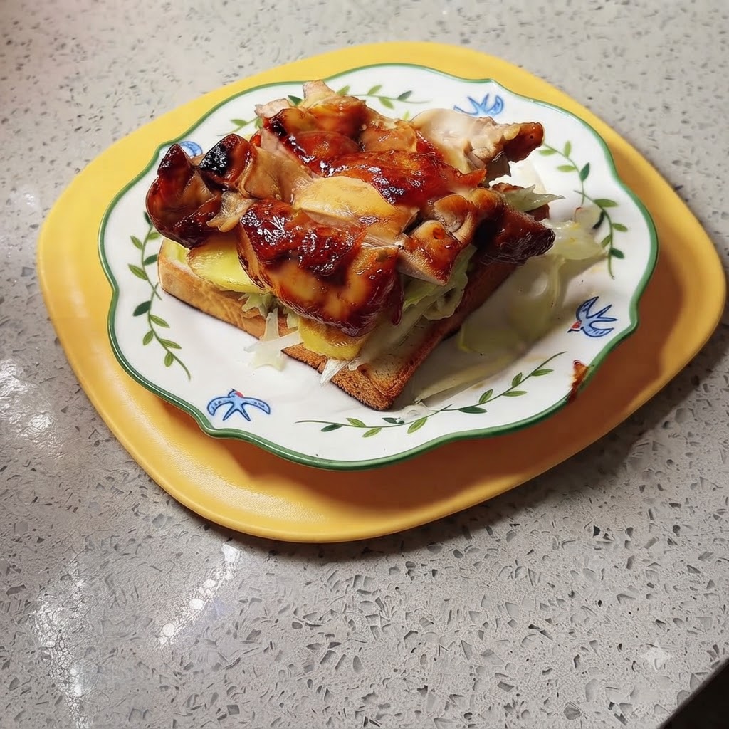 Un panino finito con pollo teriyaki e ananas posizionato su un vassoio giallo, pronto per la salsa e per essere servito.