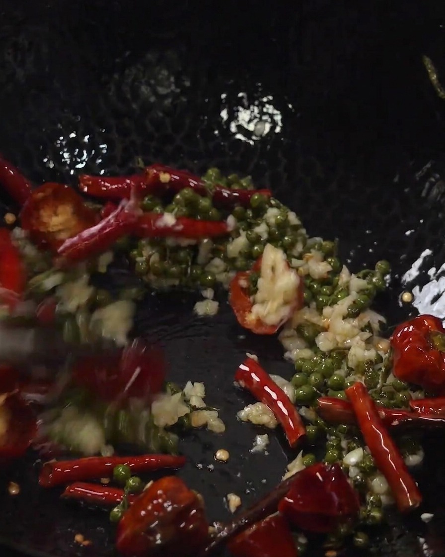 Costine di maiale fritte e aromi saltati insieme in un wok.