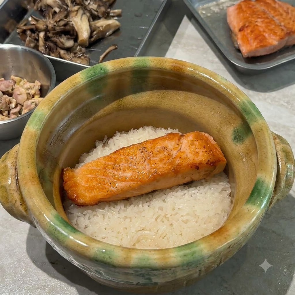 Funghi maitake saltati in padella e dorati disposti sopra il salmone e il riso allinterno della casseruola.