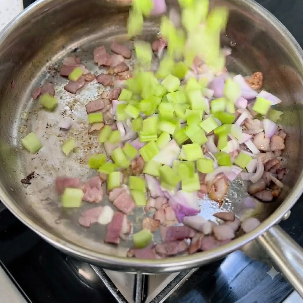 Sedano e cipolle rosse a cubetti versati in una padella calda con pancetta croccante.