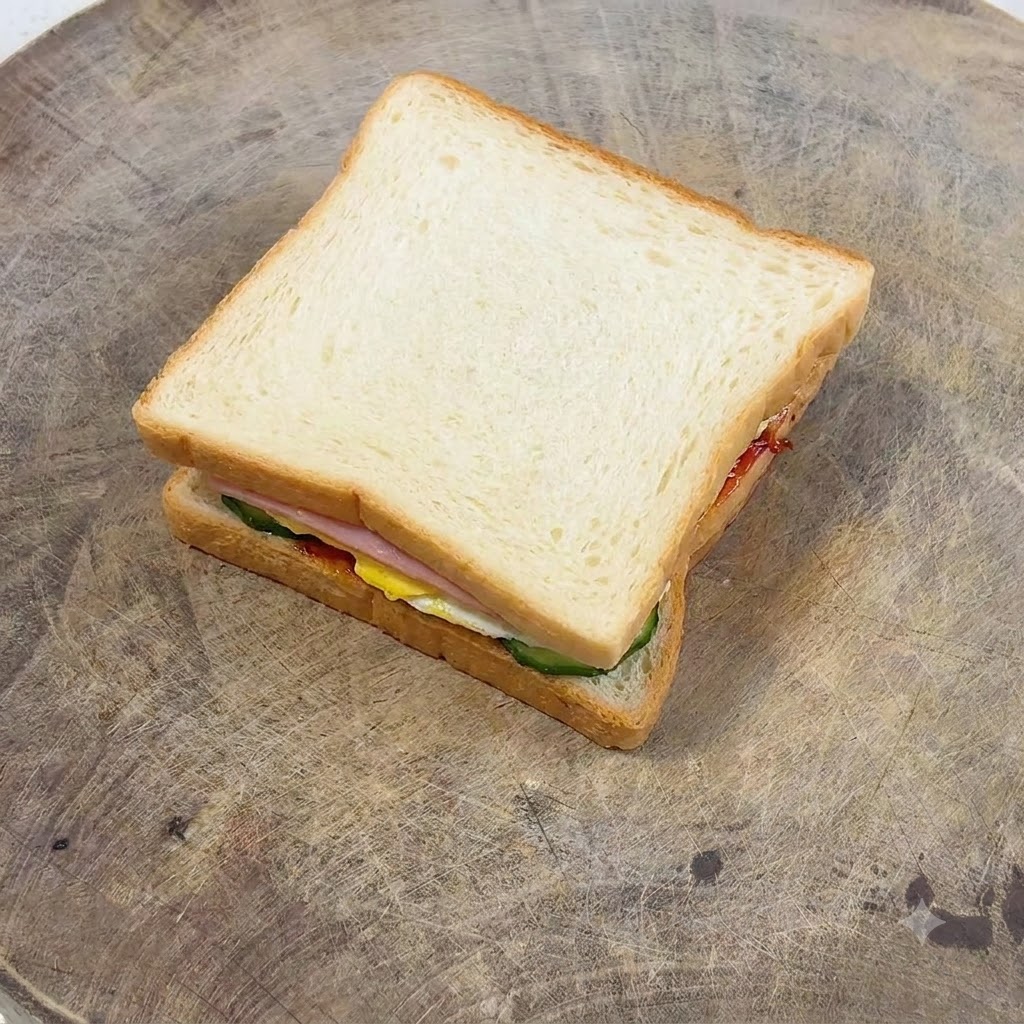 Una forchetta che spalma la maionese uniformemente su una fetta dorata di pane tostato.