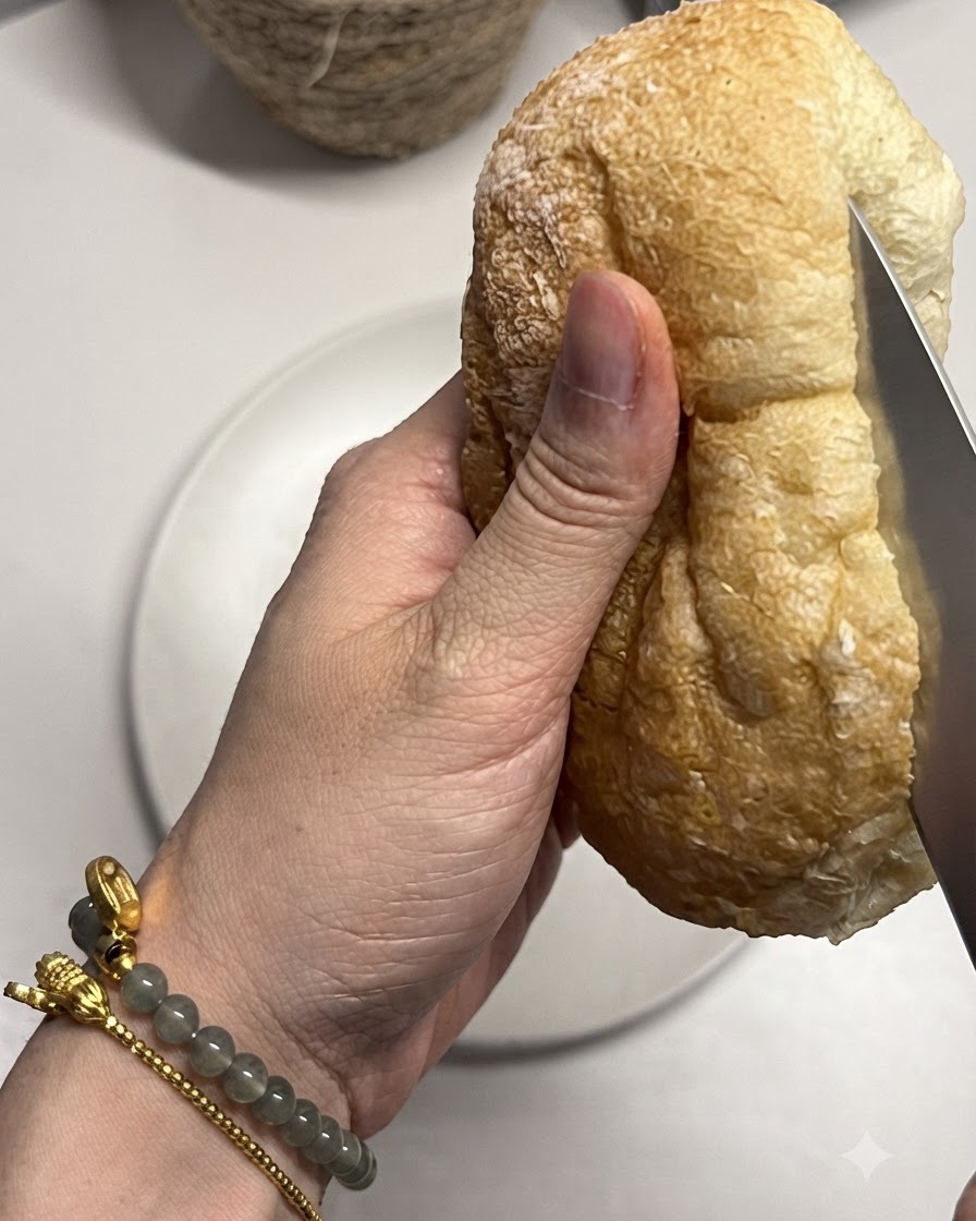 Una pagnotta di pane ciabatta tagliata a metà con un coltello.
