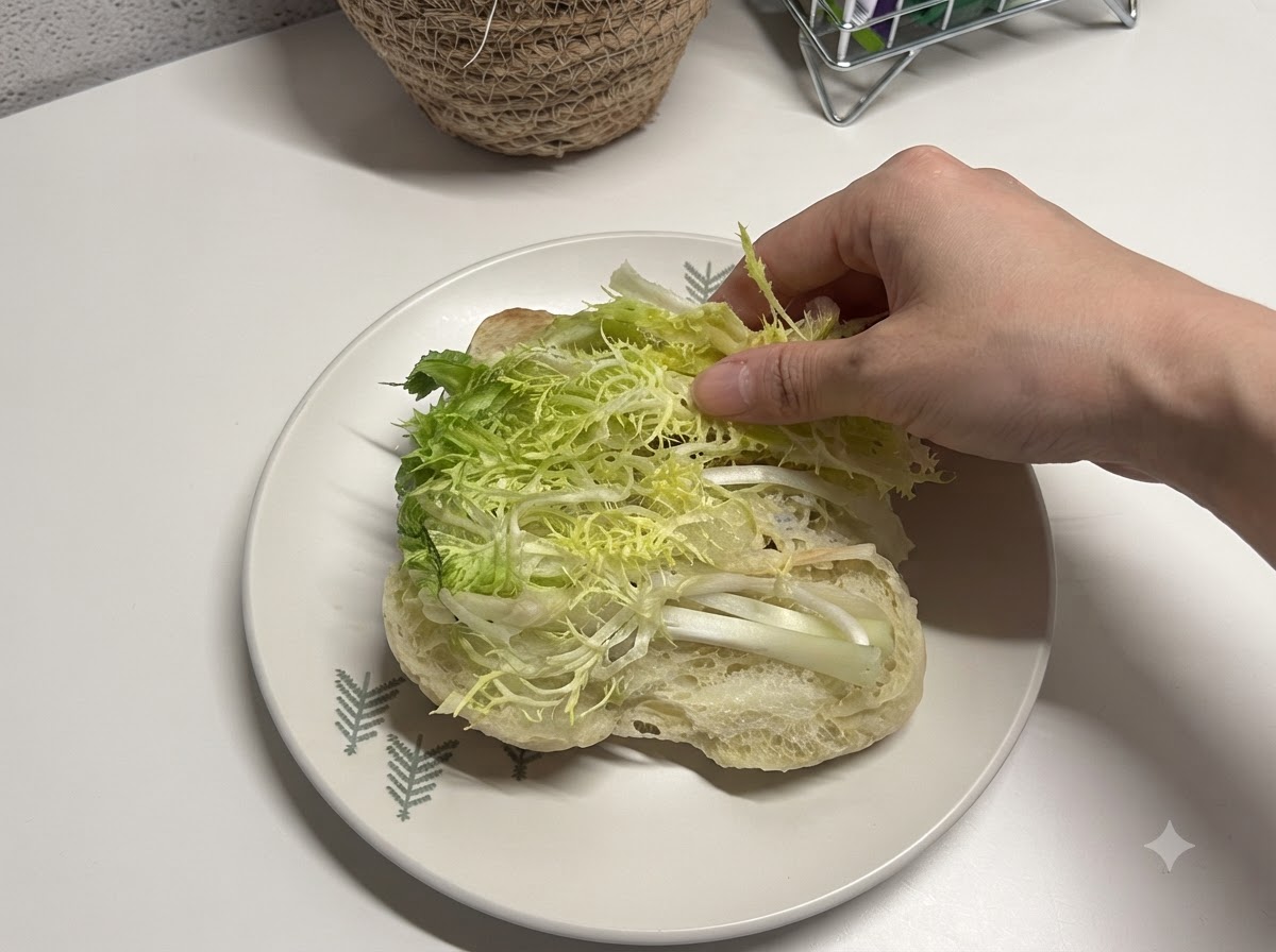 Lattuga fresca tagliata posizionata allinterno di un pane ciabatta aperto.