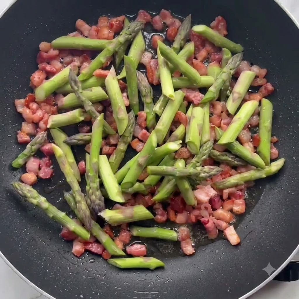 Pezzi di asparagi verdi saltati insieme alla pancetta croccante in una padella.