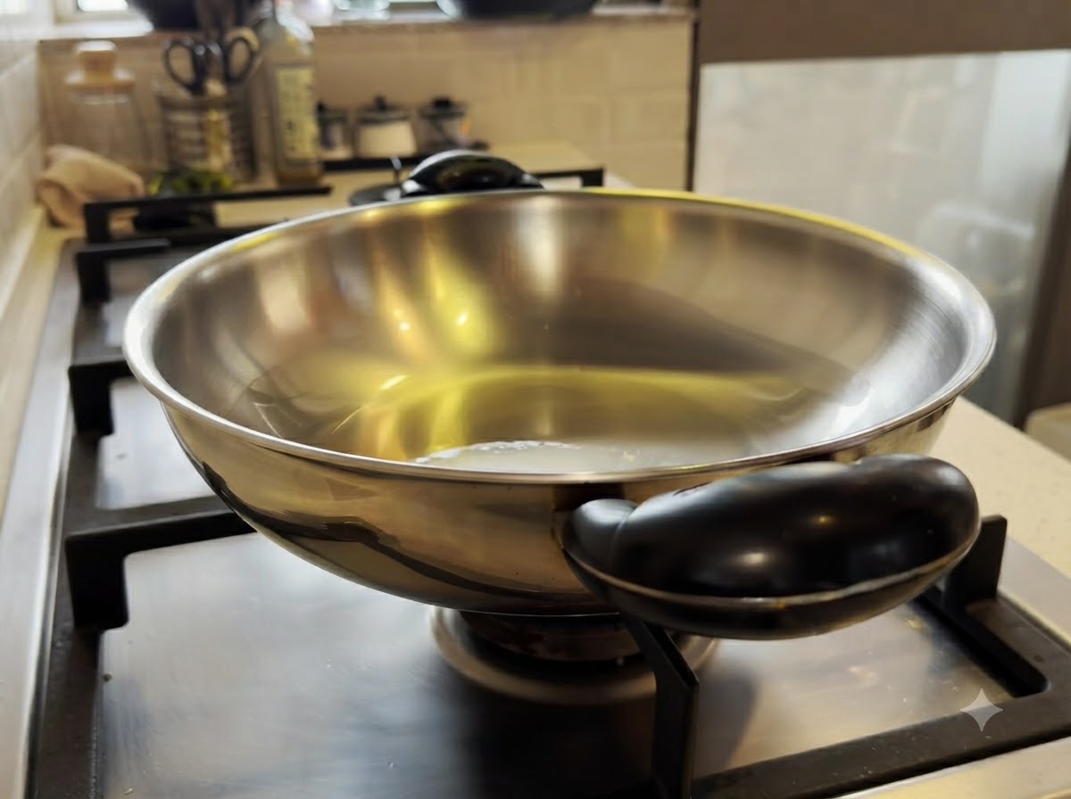 Piccoli pezzi di pollo mescolati in un wok di metallo riscaldato con olio doliva.