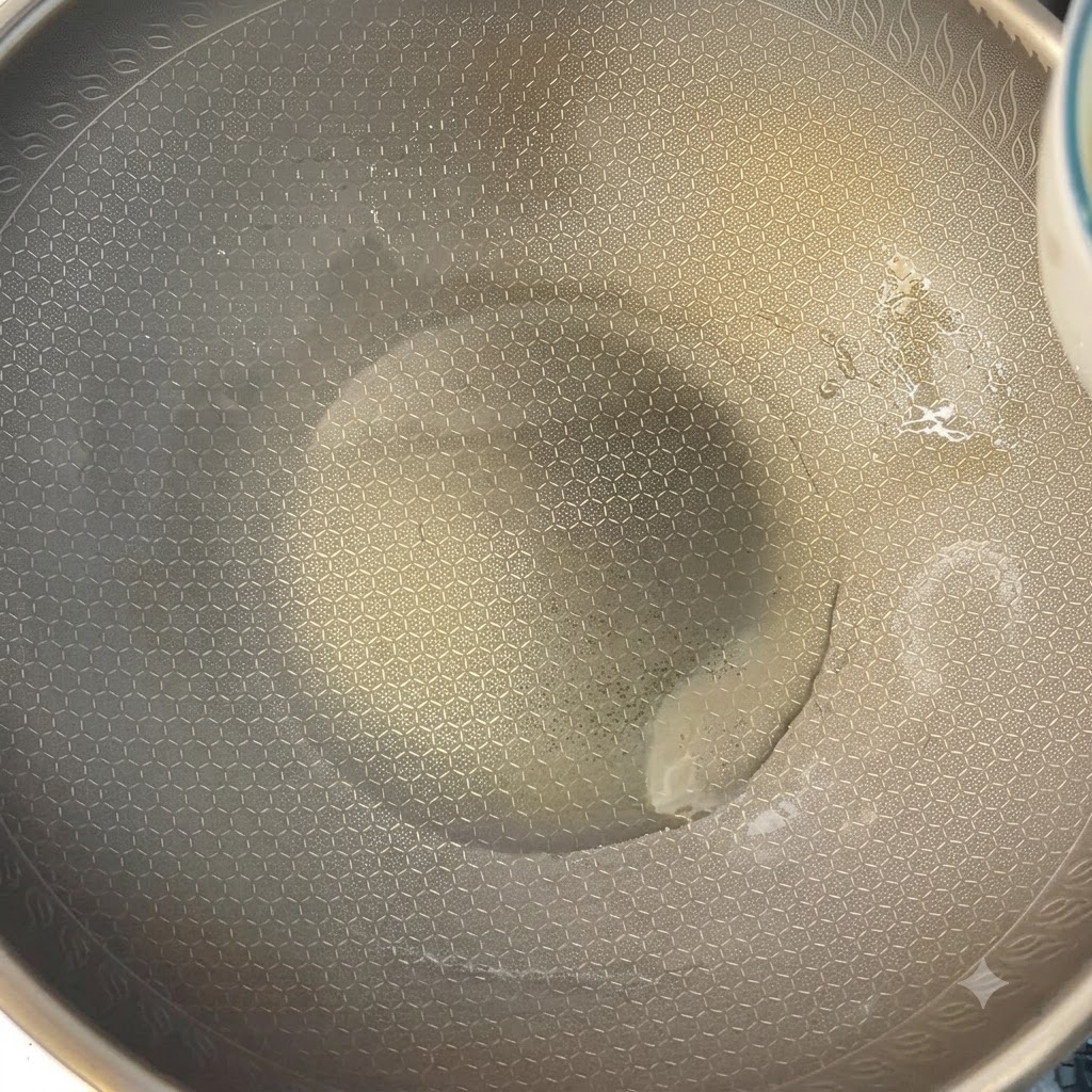 Uova sbattute cotte in un wok riscaldato usando le bacchette.