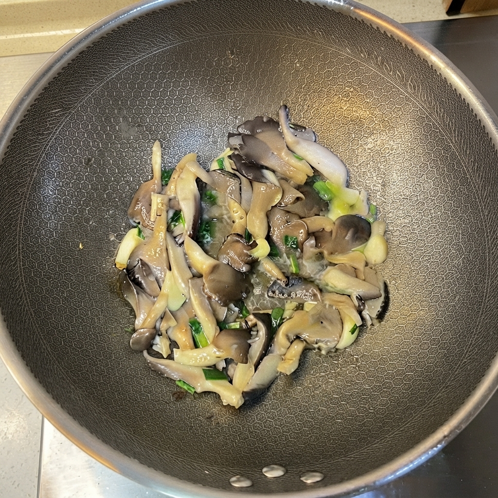 Funghi oyster cotti e aromi mescolati allinterno del wok.