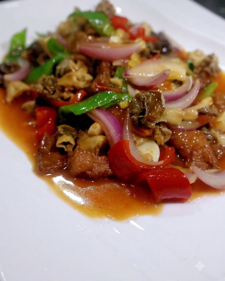 Un soffritto finito di funghi misti, peperoni, bok choy e carne servito su un piatto bianco.