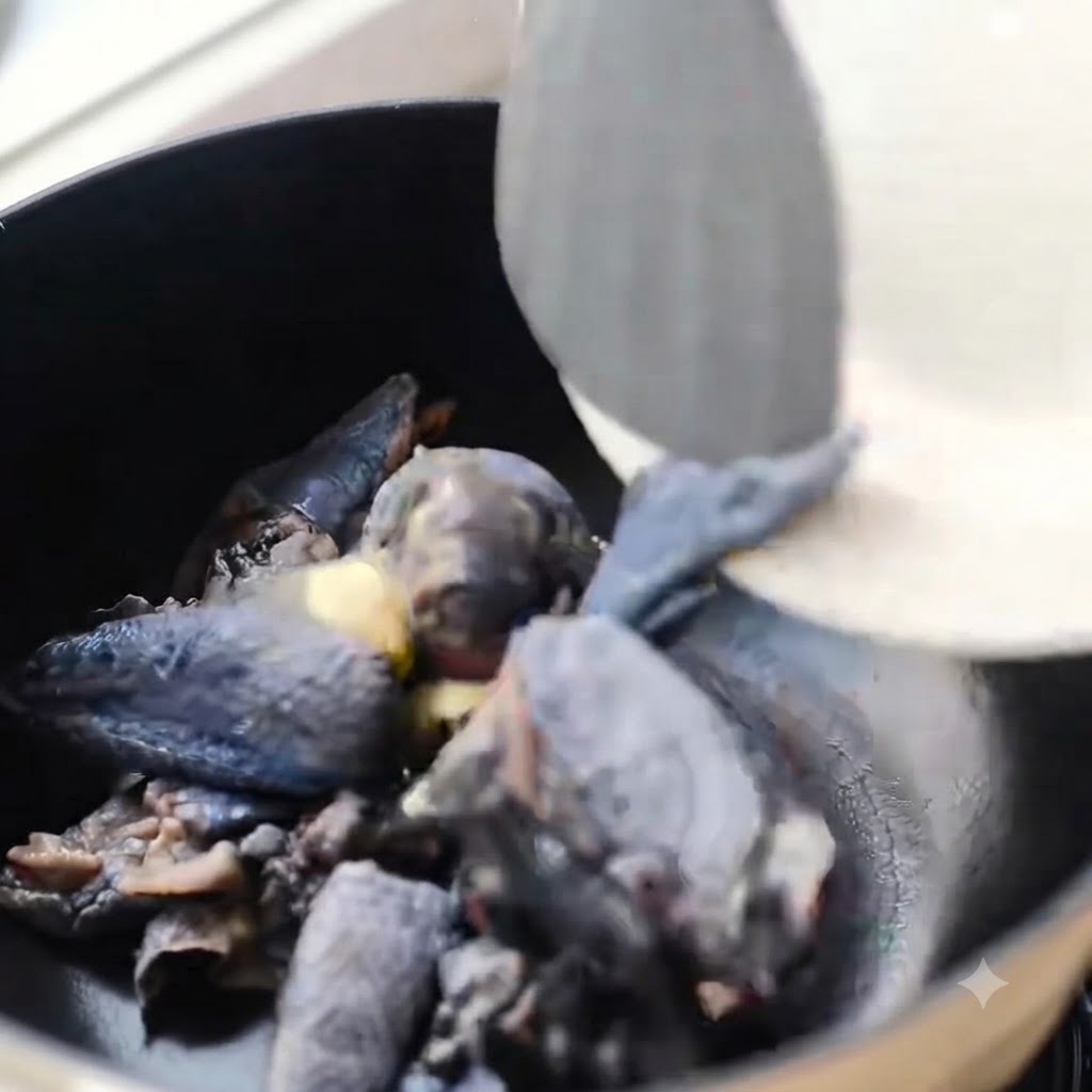 Pezzi di pollo dalla pelle nera saltati in una pentola nera con zenzero.