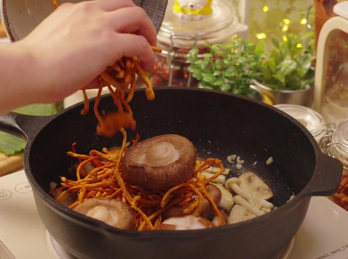 Funghi shiitake e cordyceps messi in ammollo aggiunti alla padella.