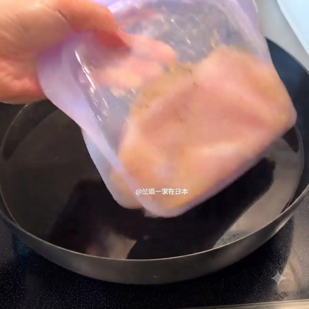 Un contenitore viola sigillato con pollo marinato inserito in una pentola piena dacqua.
