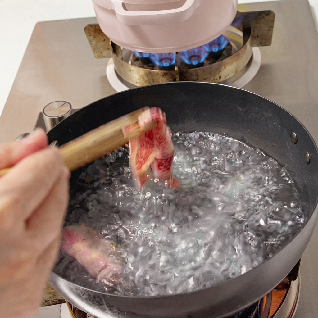 Fettine di manzo fresche immerse in una pentola di acqua bollente con le bacchette.