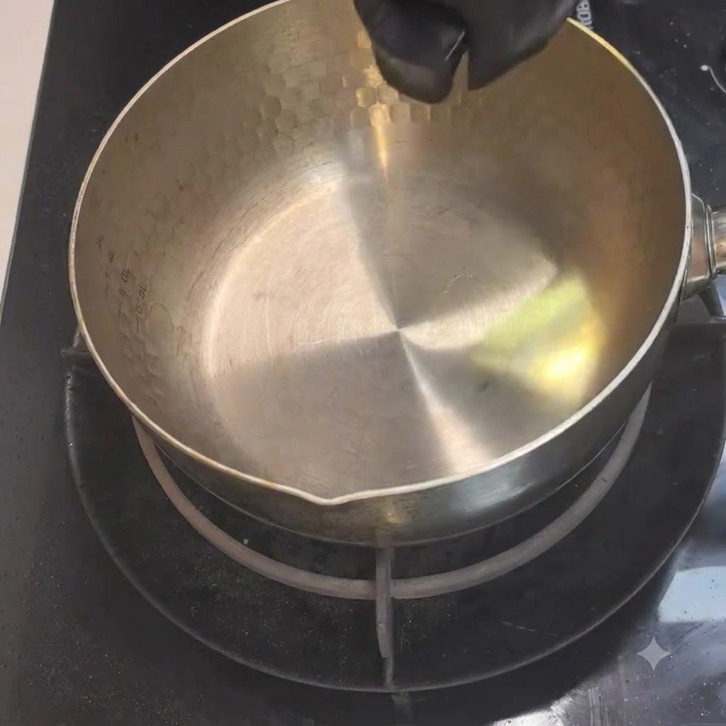 Olio da cucina versato da un piccolo contenitore in una pentola di metallo riscaldata sul fuoco.