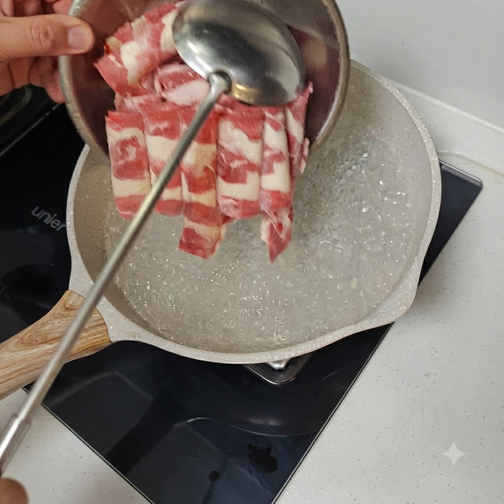 Carne di manzo tagliata sottile immersa in una padella di acqua bollente con un mestolo di metallo.