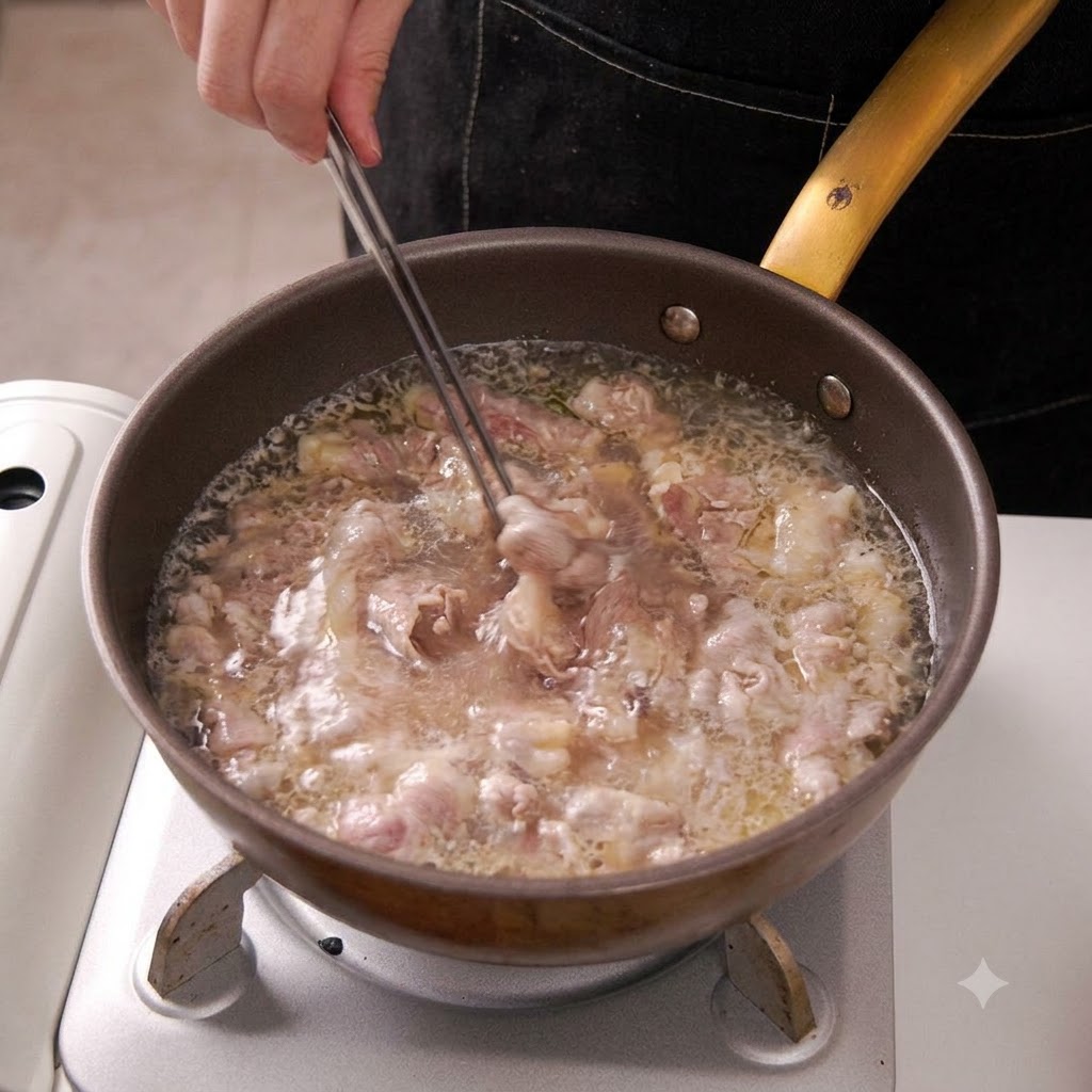 Le pinze sollevano fettine di manzo sbollentate dallacqua bollente in una padella.