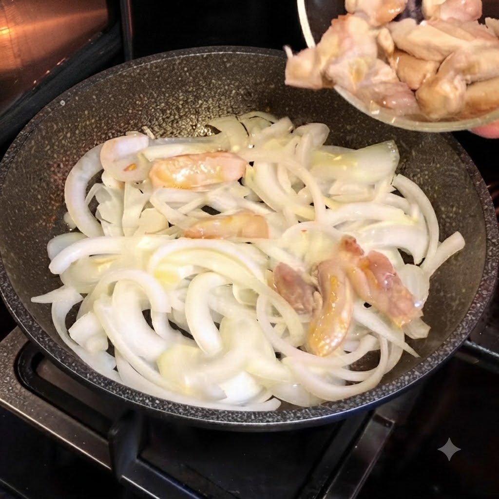 Pezzi di pollo parzialmente cotti versati da una piccola ciotola di vetro in una padella calda piena di cipolle bianche affettate.