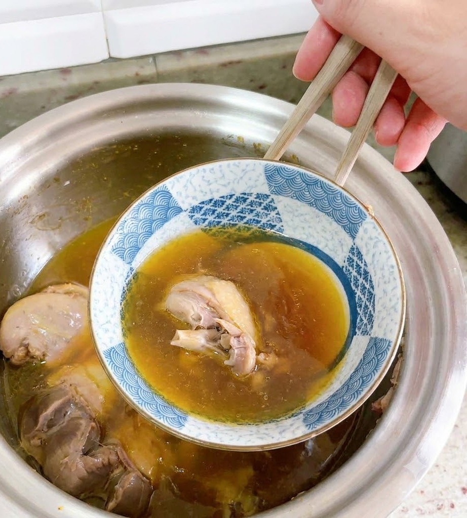 Una ciotola di ceramica capovolta viene accuratamente sollevata fuori dalla zuppa danatra con le bacchette.