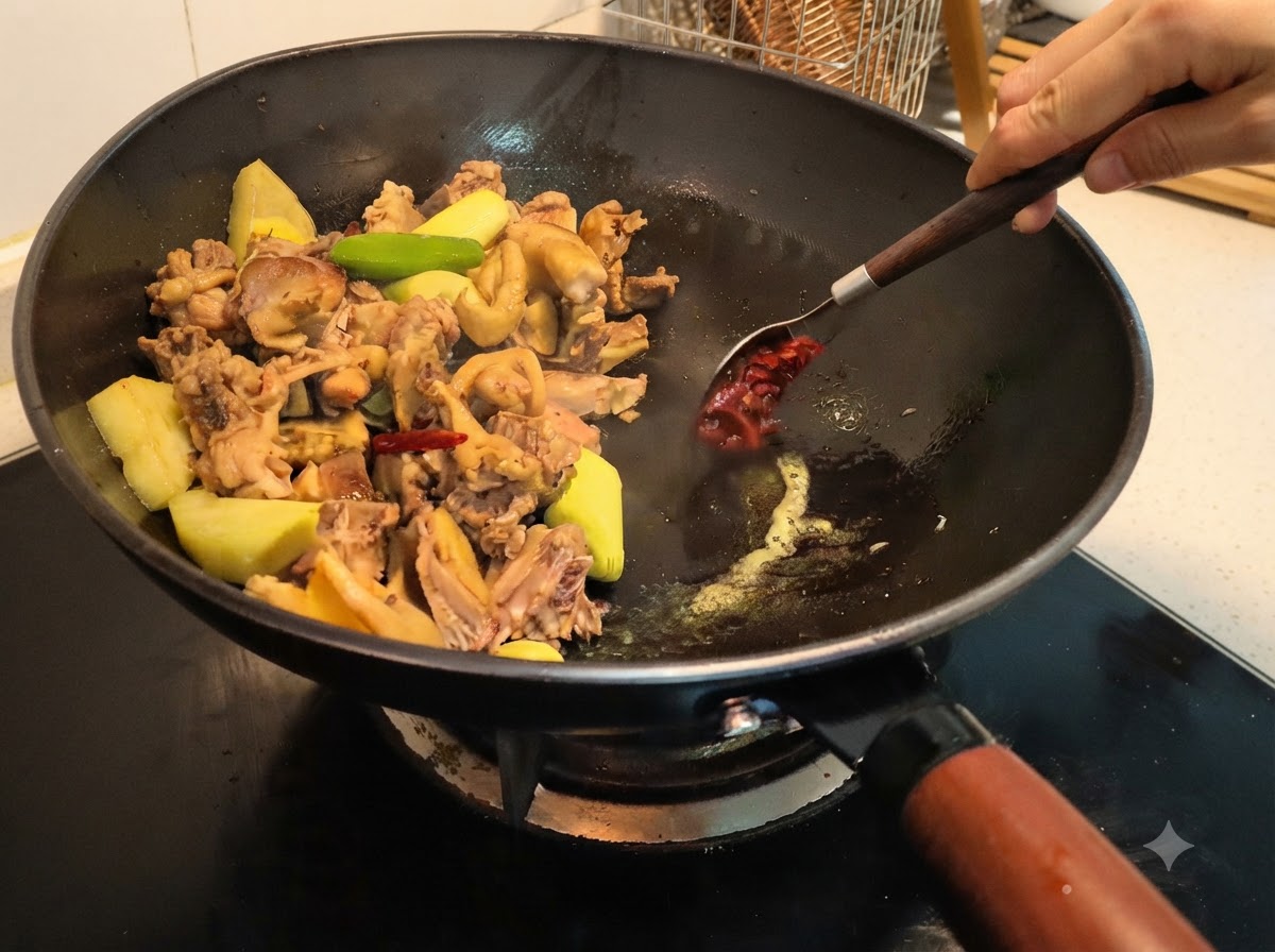 Pasta di fave raccolta e mescolata nel wok con gli altri ingredienti usando un cucchiaio.