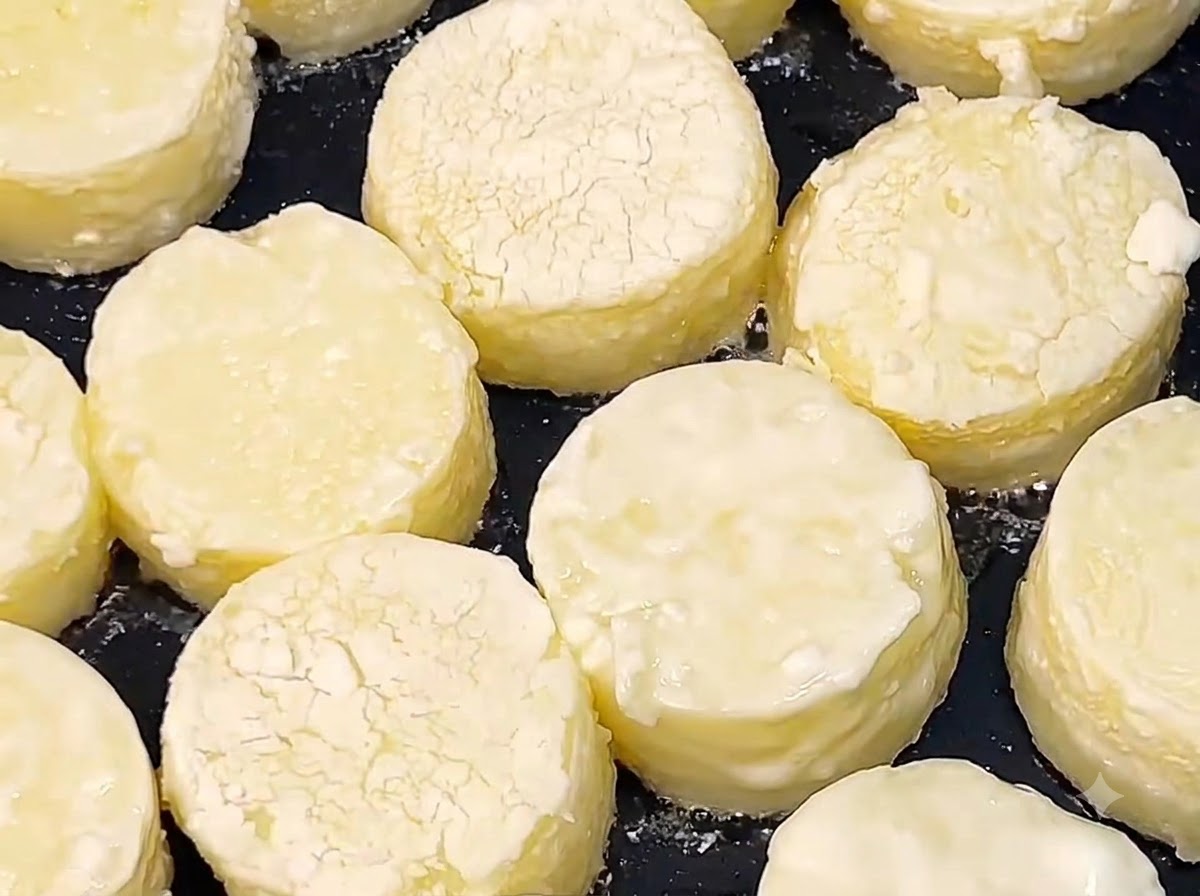 Rondelle di tofu giapponese che friggono nellolio caldo in una padella nera fino a doratura della superficie.