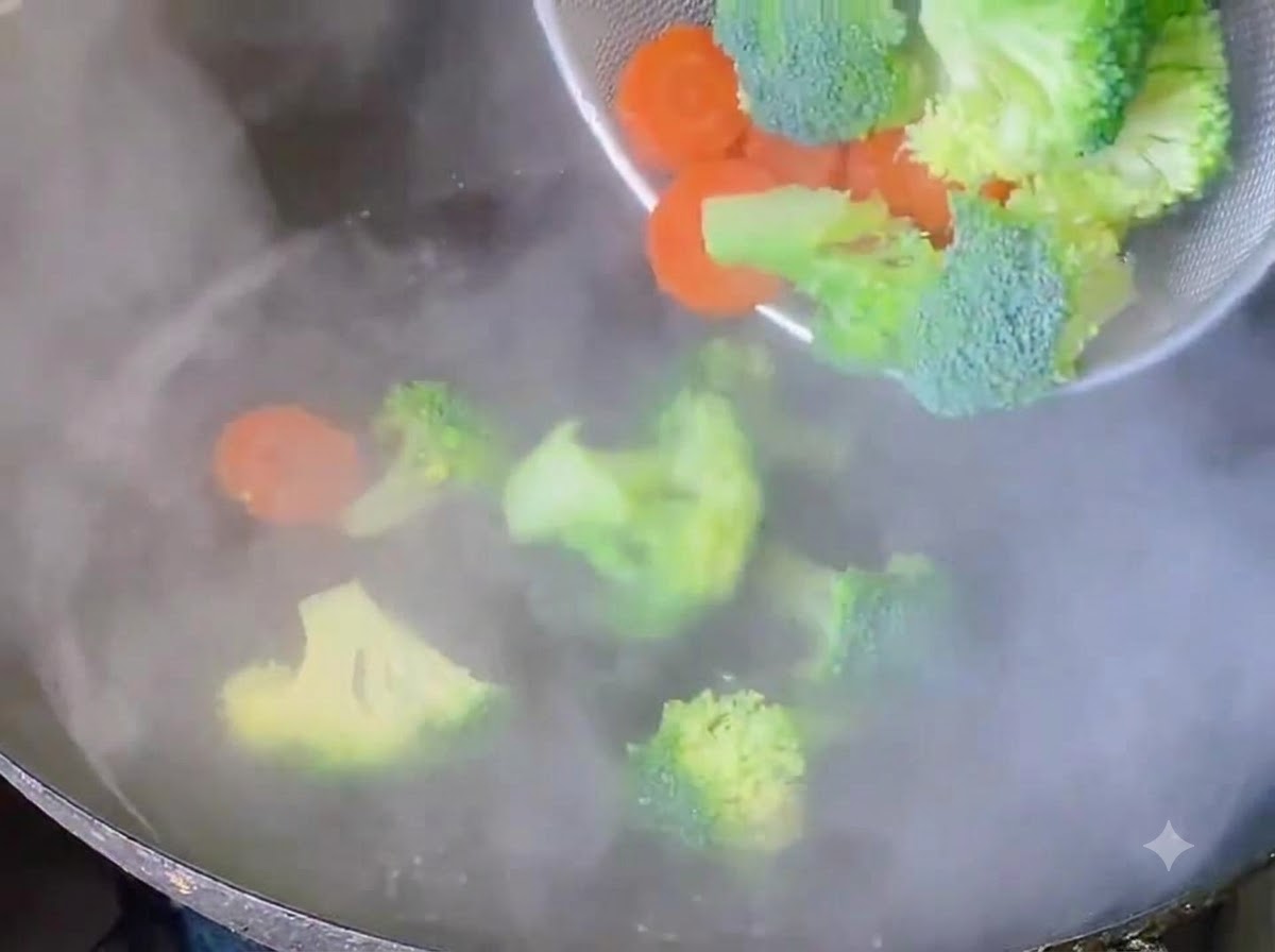 Cimette di broccoli e fette di carota sbollentate in acqua bollente.