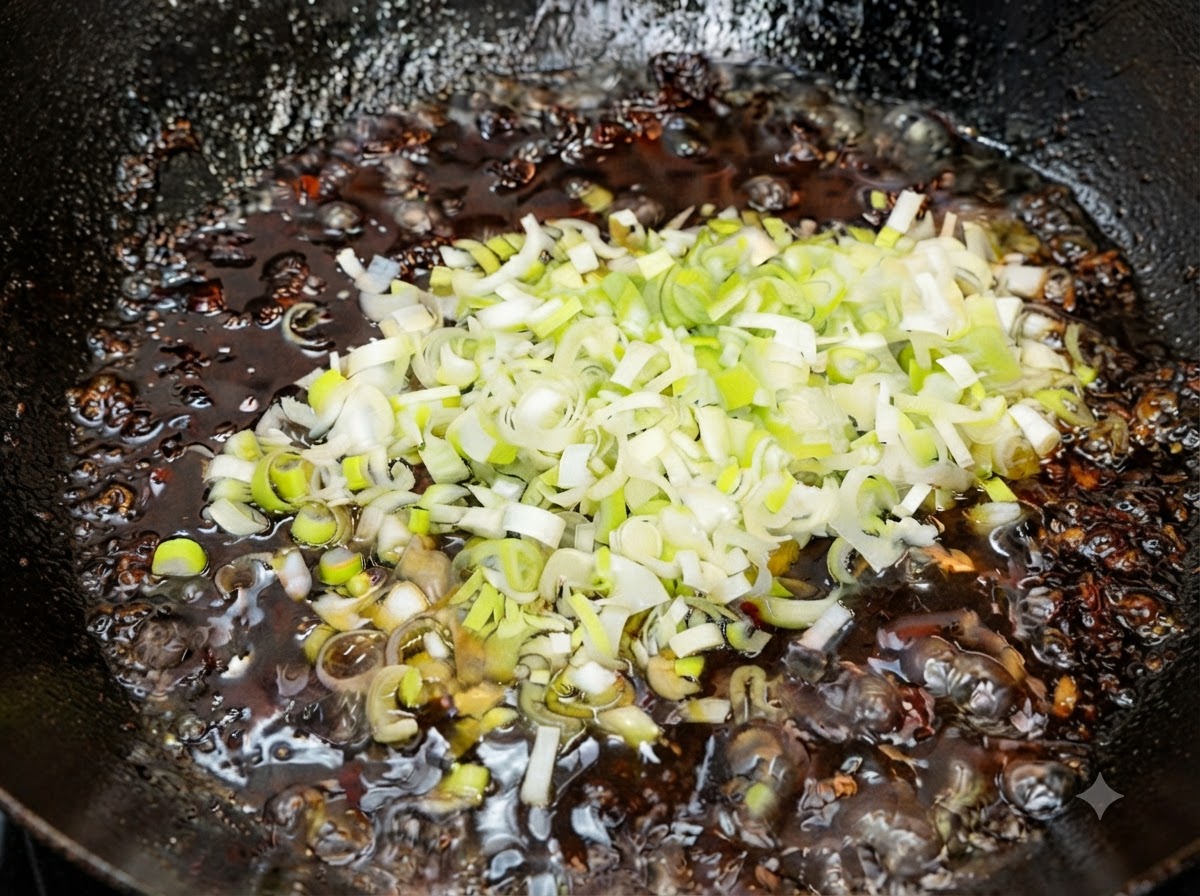 Cipollotti verdi freschi tritati mescolati nella salsa fritta calda finita fuori dal fuoco.