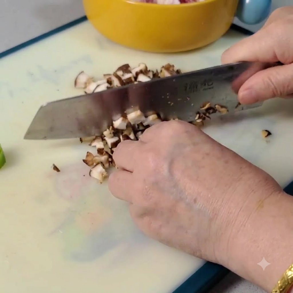 Funghi shiitake crudi affettati e tritati a piccoli pezzi su un tagliere.