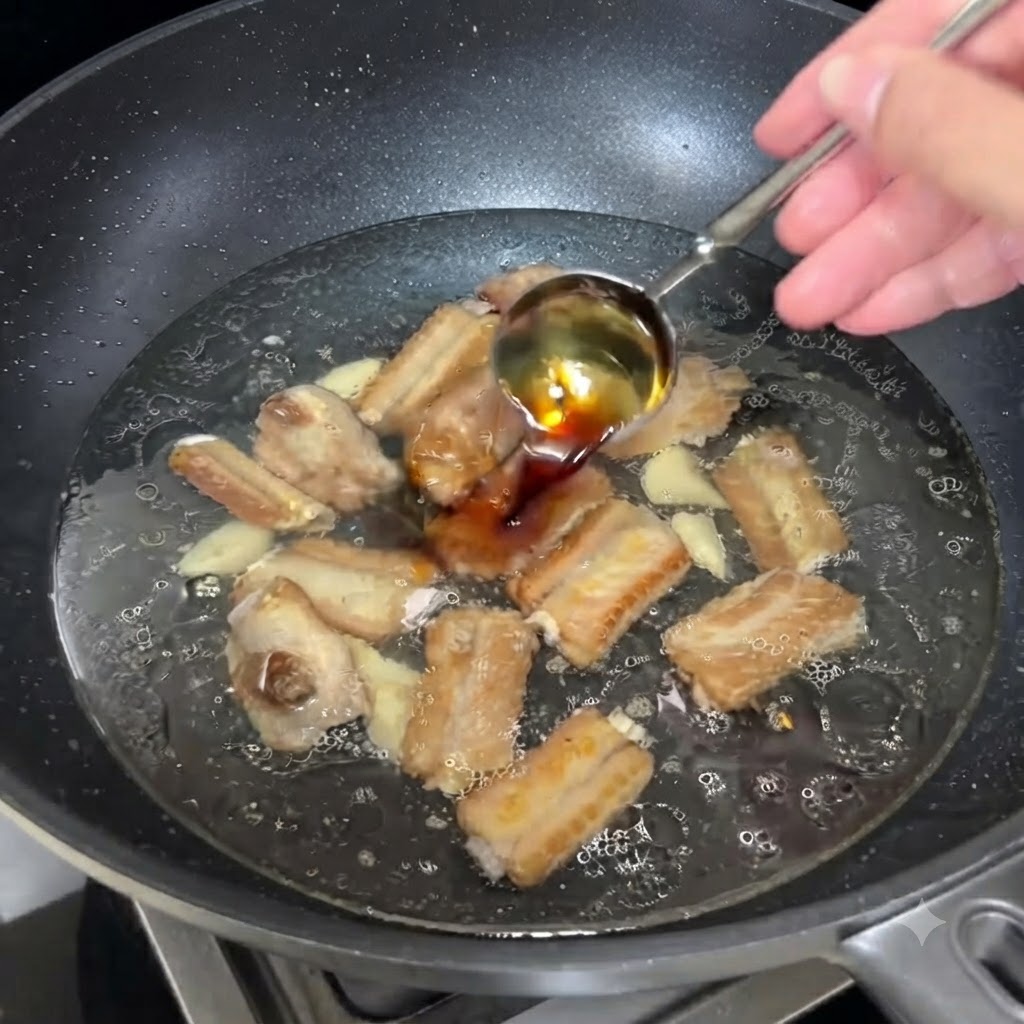 Un cucchiaio di salsa di soia chiara versato nel brodo bollente con le costine.