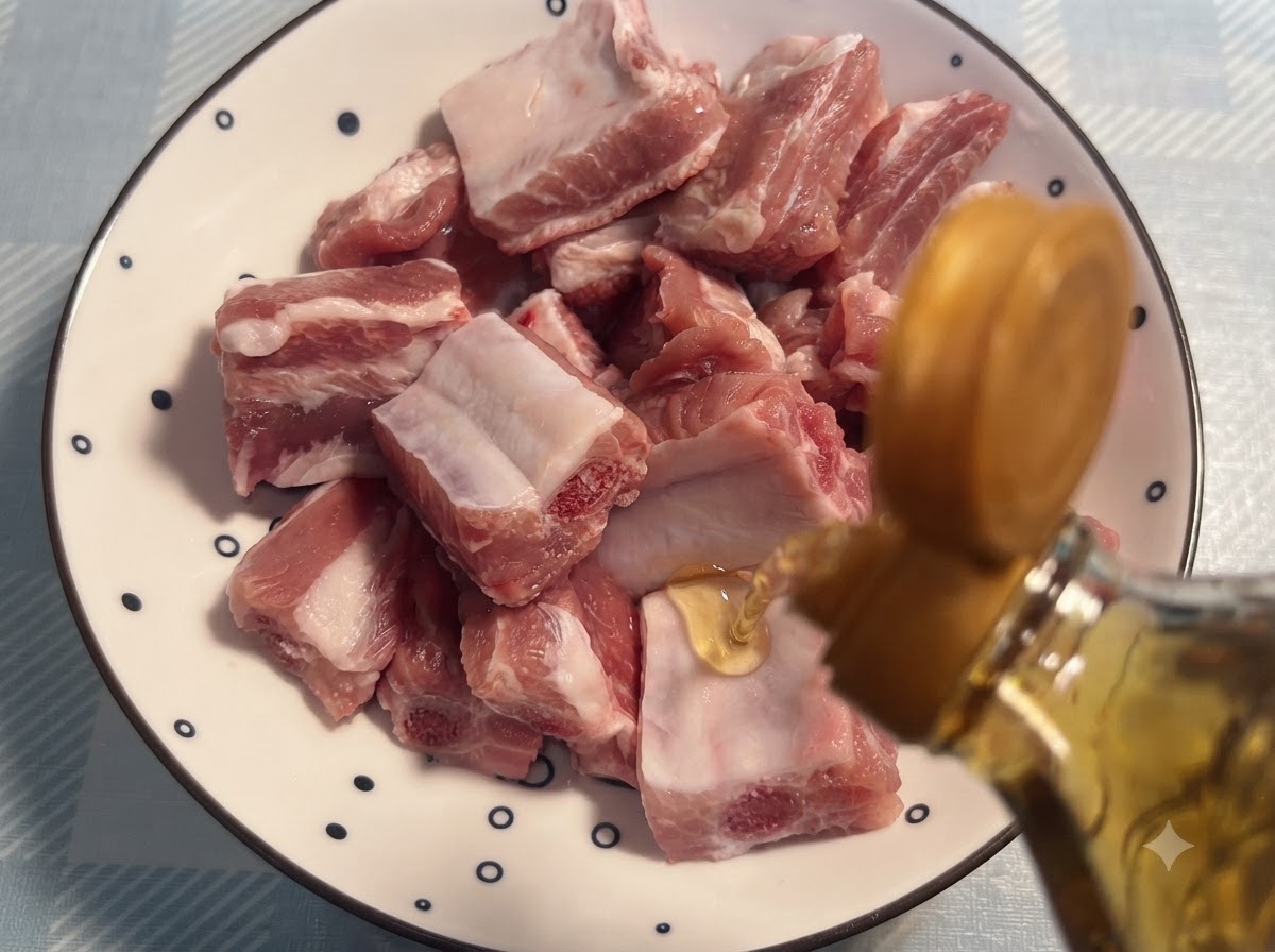 Vino da cucina versato da una bottiglia su costine di maiale crude disposte su un piatto decorato.