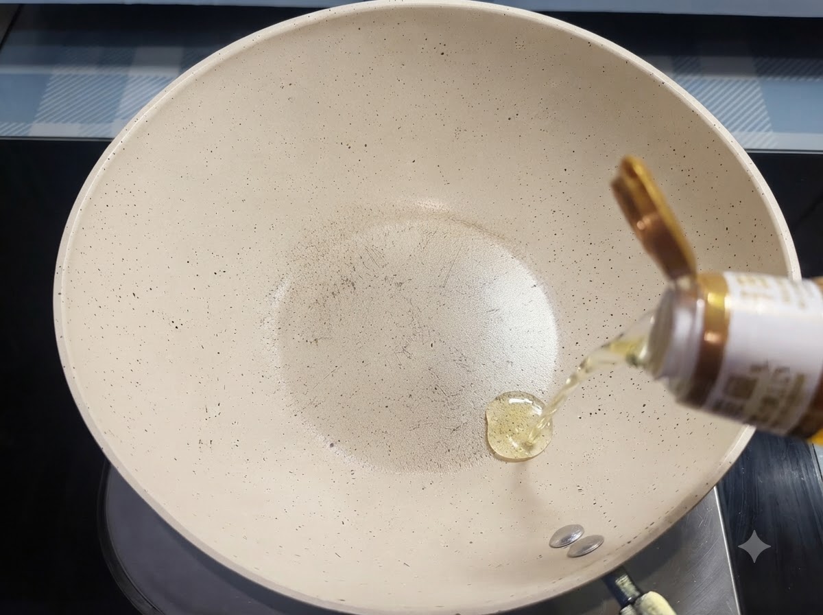 Olio da cucina che scende da una bottiglia in una padella di ceramica bianca.