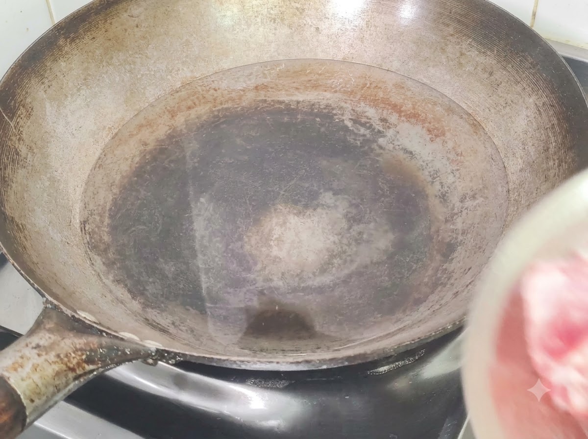 Costine di maiale messe in un wok pieno di acqua fredda, zenzero e vino da cucina per la scottatura.