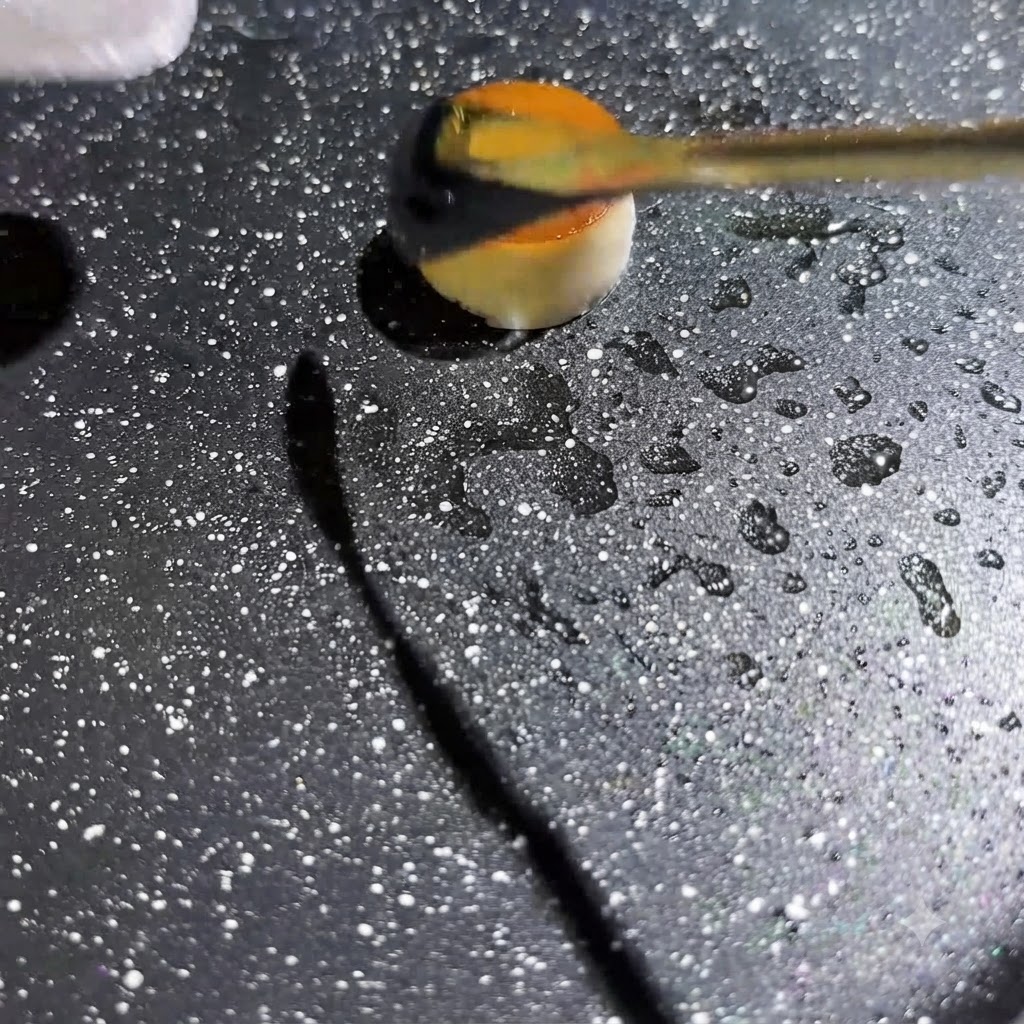Liquido duovo giallo spremuto al centro di un piccolo anello di fungo cavo in una padella calda e maculata.
