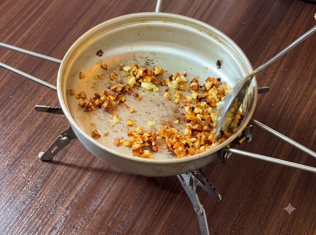 Aglio tritato saltato e dorato nel burro allinterno di una padella.