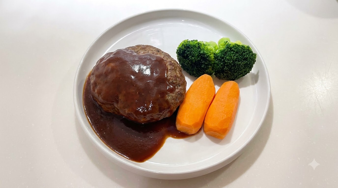 Un succulento hamburger giapponese ricoperto da una salsa scura e lucida, servito con carote e broccoli.