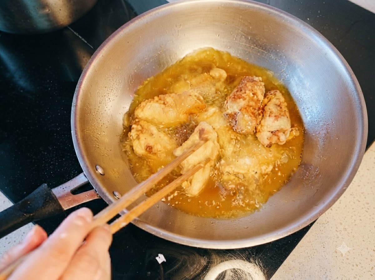 Ali di pollo mescolate e doppie fritte in olio caldo con le bacchette.