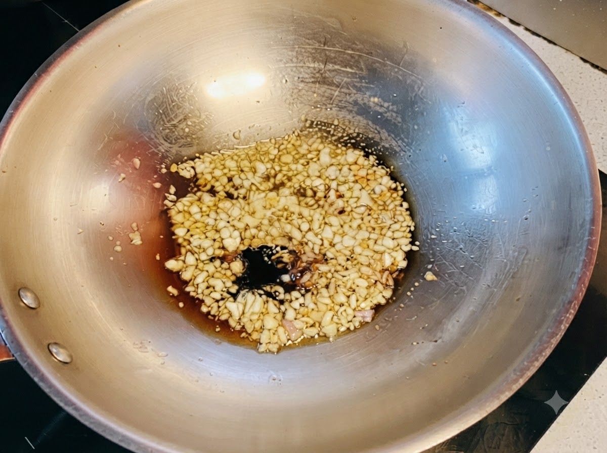 Salse di soia scura e chiara combinate con il miele che sobbollono sullaglio saltato nel wok.